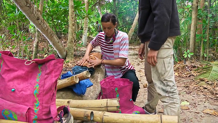 Genevieve searching Aubry's bag